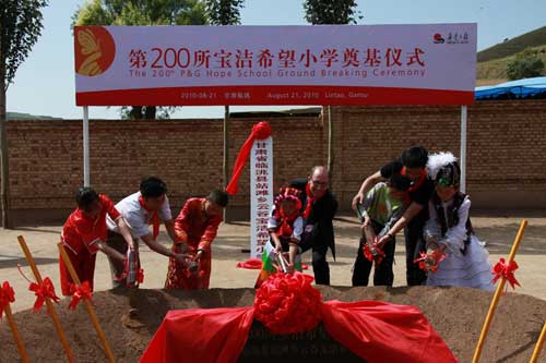 希望小学的学生代表与宝洁公司全球对外关系执行官柯锐思一起为学校奠基培土。魏勇摄